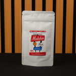 White matcha powder package with red label on a wooden background