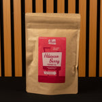 Kraft paper tea bag with a red label featuring 'Mam' branding on a wooden background.