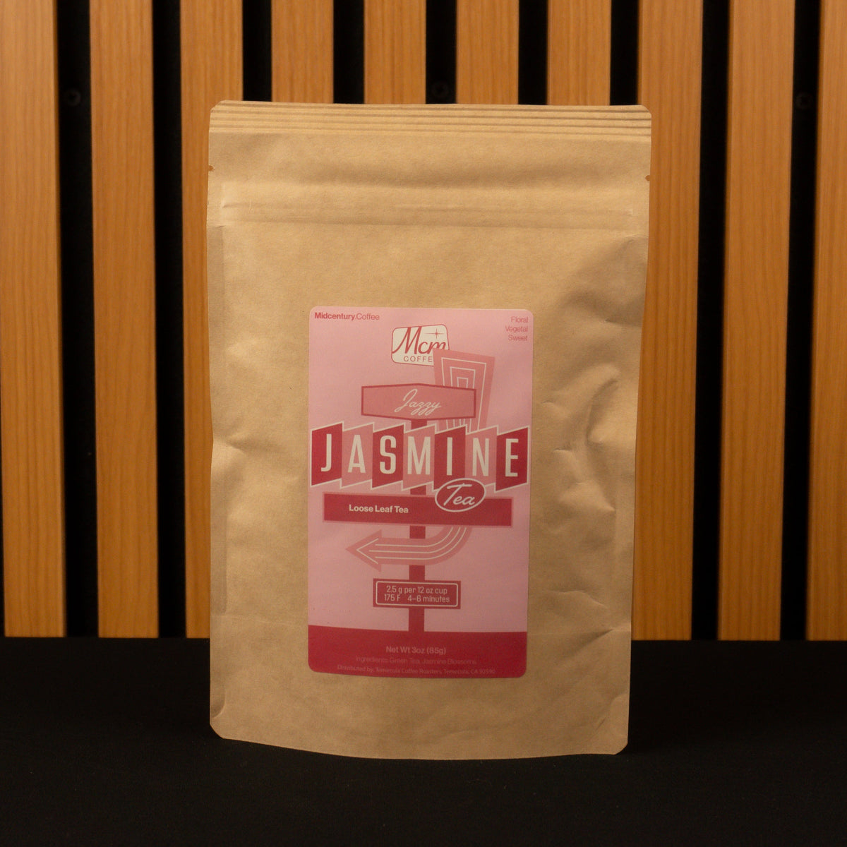 Kraft paper tea bag with a pink label on a wooden background
