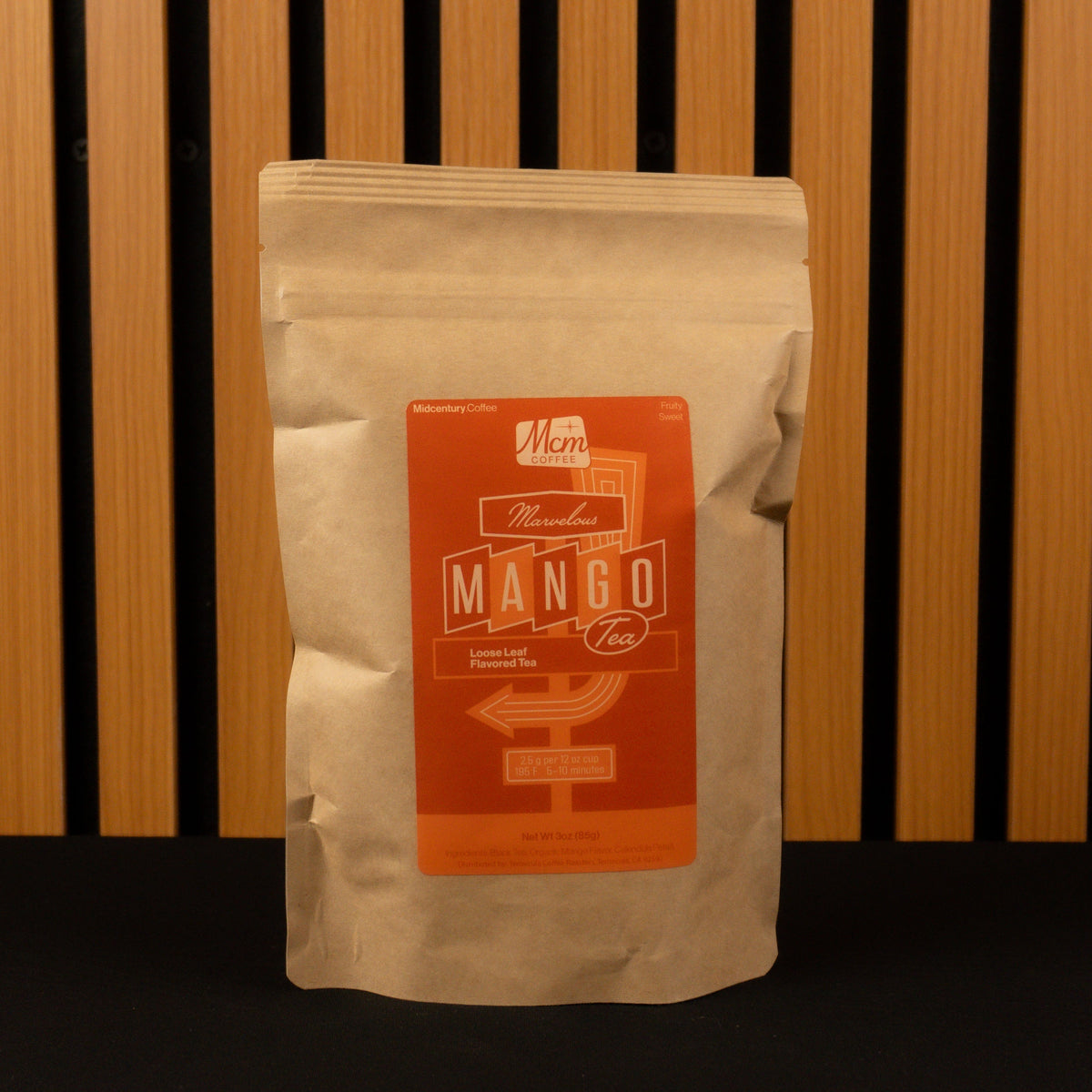 Mango Tea bag with a label on a wooden slatted background