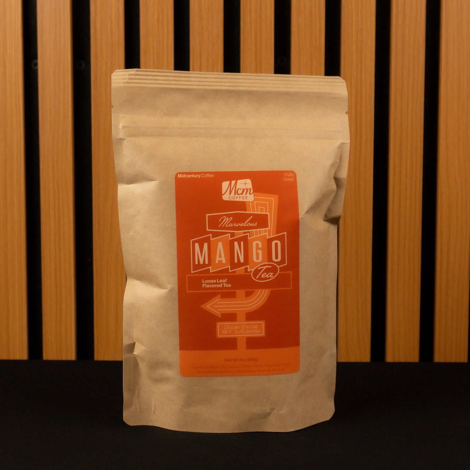 Mango Tea bag with a label on a wooden slatted background