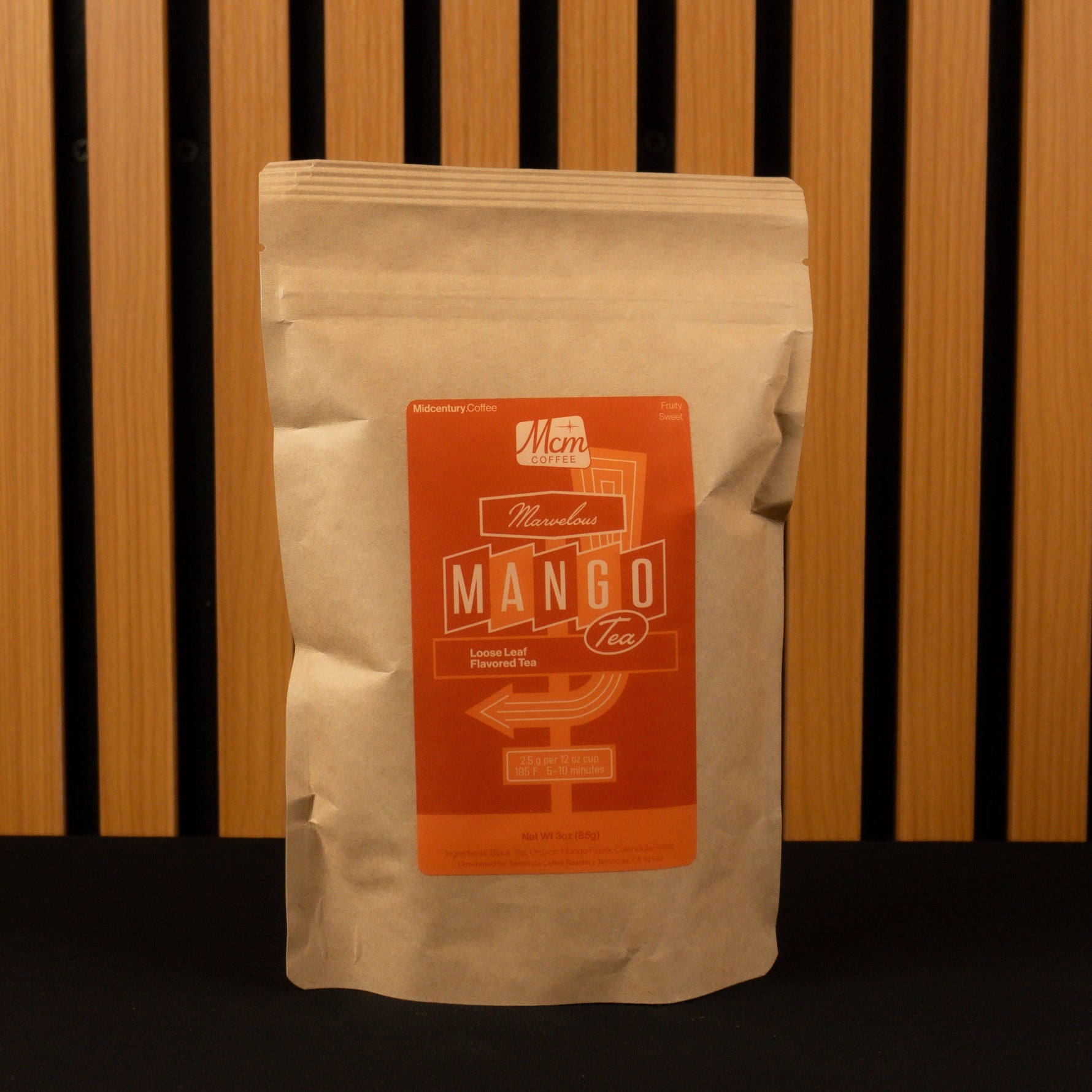 Mango Tea bag with a label on a wooden slatted background