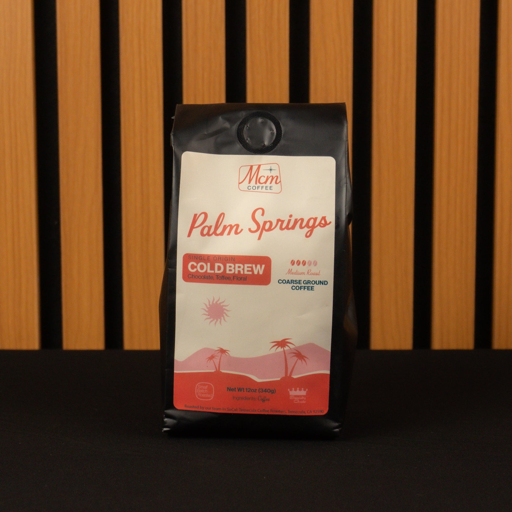 Coffee bag labeled 'Palm Springs Cold Brew' by Mimi Coffee against a striped background