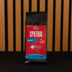Coffee package labeled 'Sputnik Decaf' on a wooden slat background