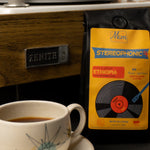 Coffee cup with a package Ethiopia coffee next to a vintage record player.